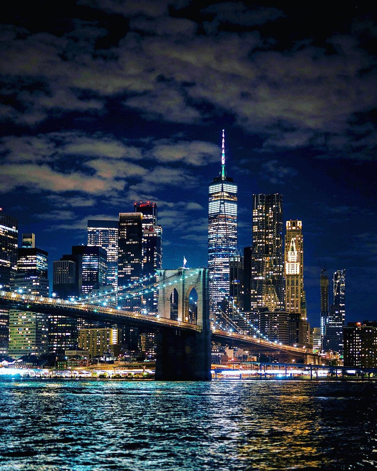 Manhattan and a lit suspension bridge at night