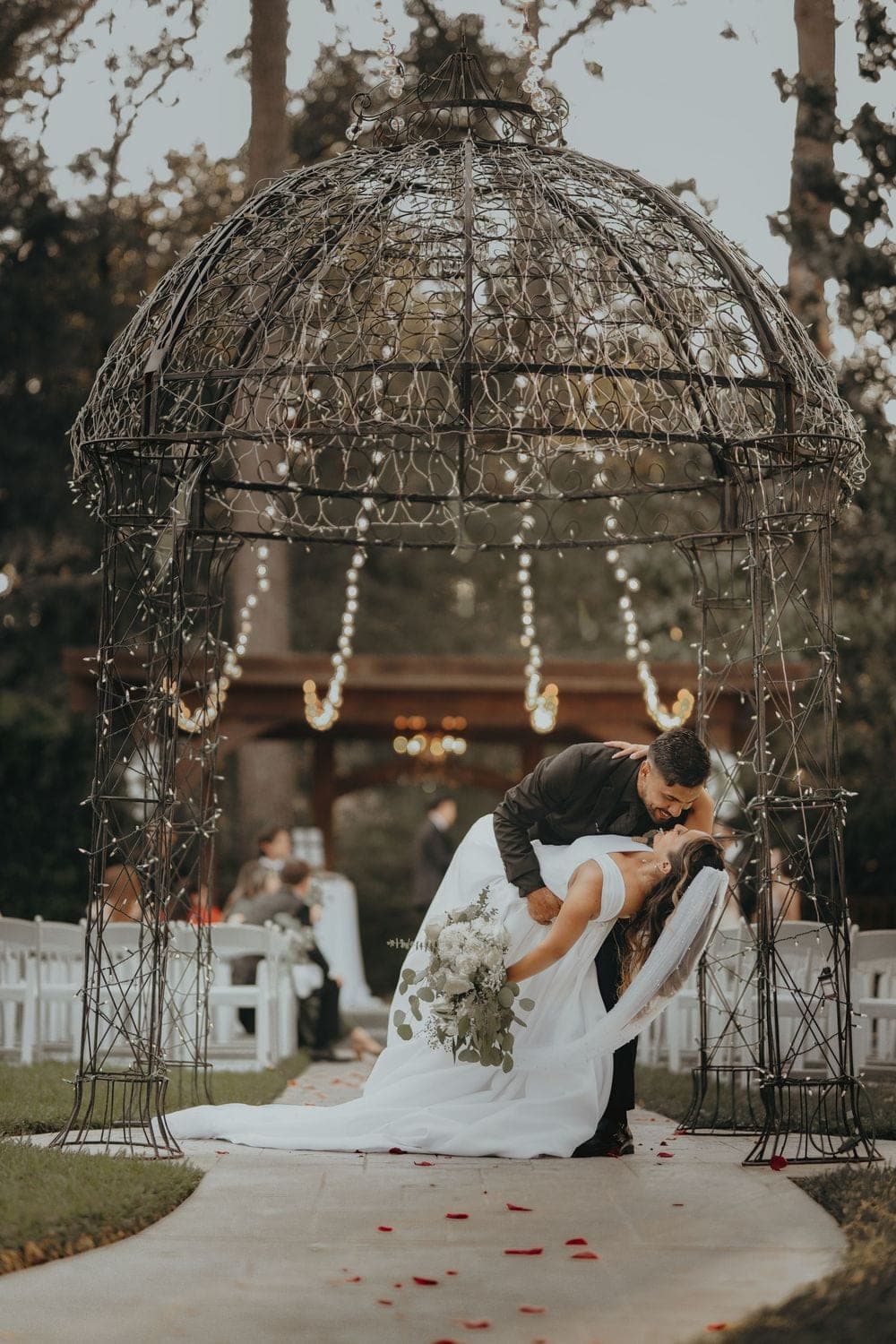 A couple beneath a lit garden gazebo